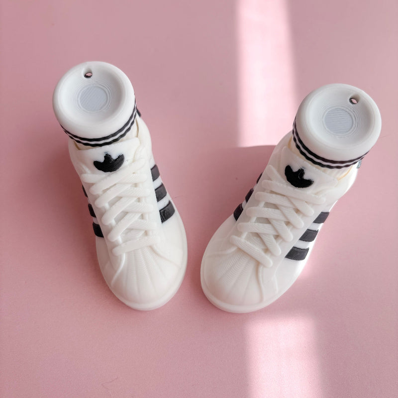 White high-top sneakers with black stripes on a pink background