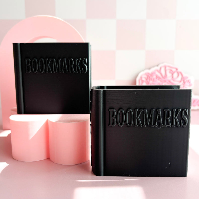 Two black containers labeled 'BOOKMARKS' on a pink and white checkered background.