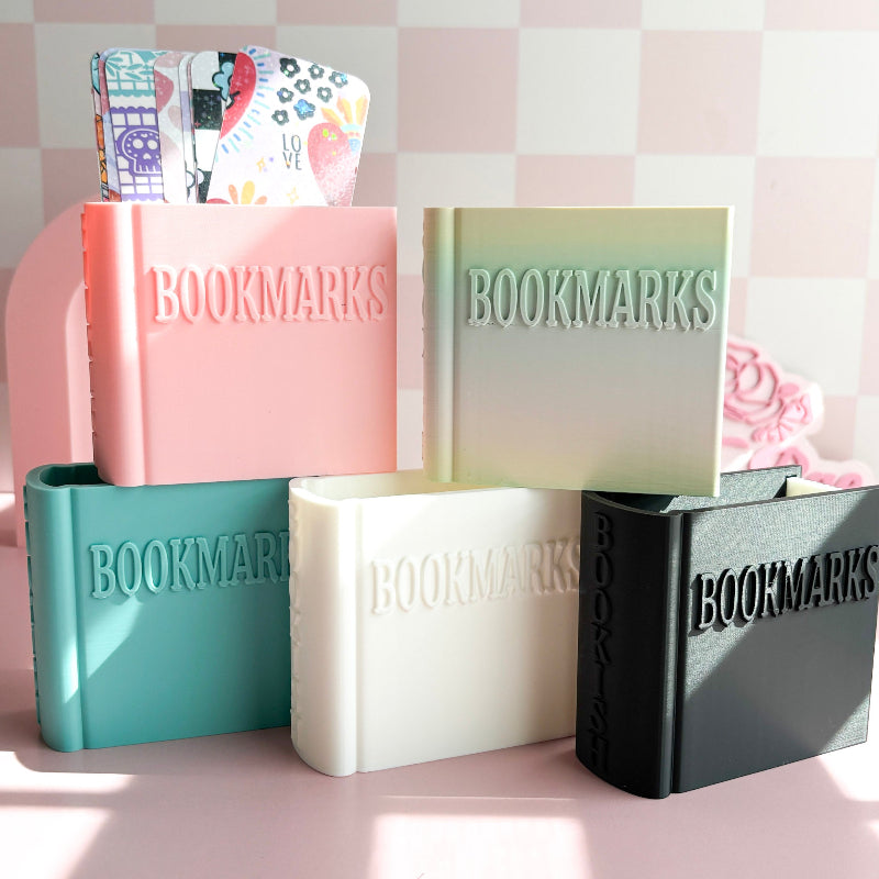 Set of colorful 'BOOKMARKS' holders on a pink checkered background