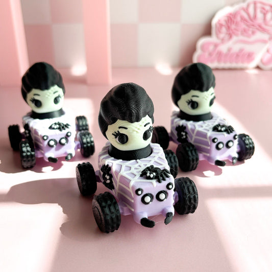 Three small toy cars with figurine fidget clicker with skeleton characters on a pink checkered background