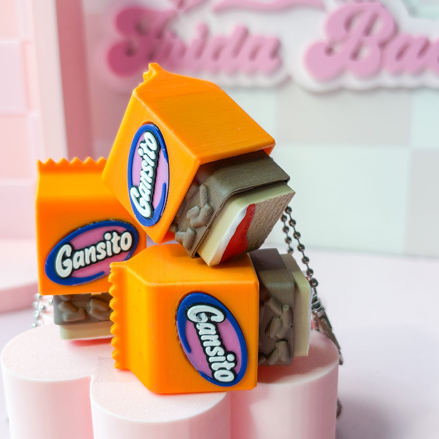 Gansito candy-themed keychain on a pink stand with a blurred background