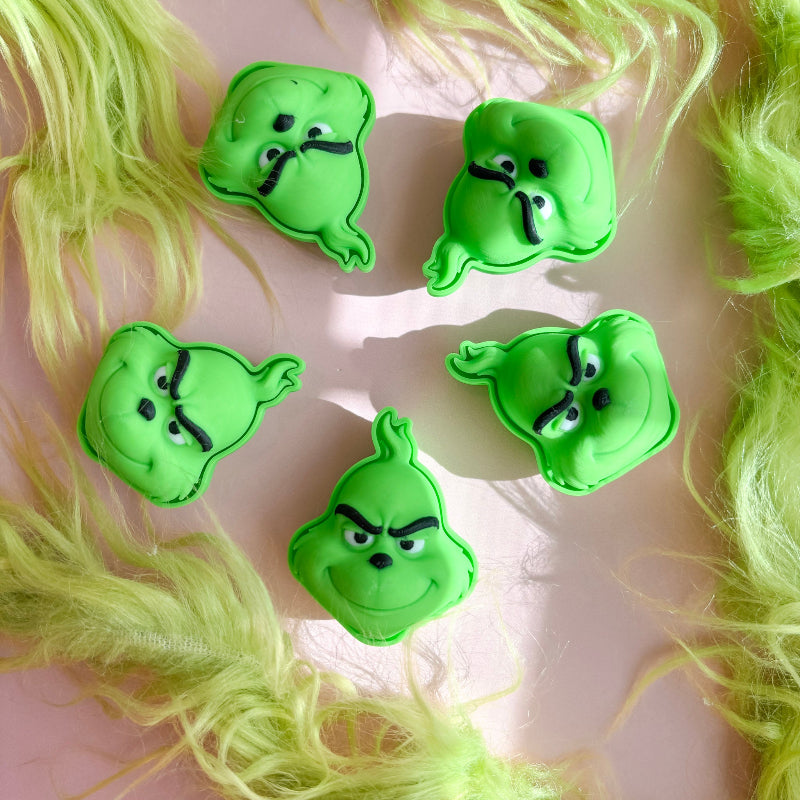 Grinch shaped clicker on a pink background