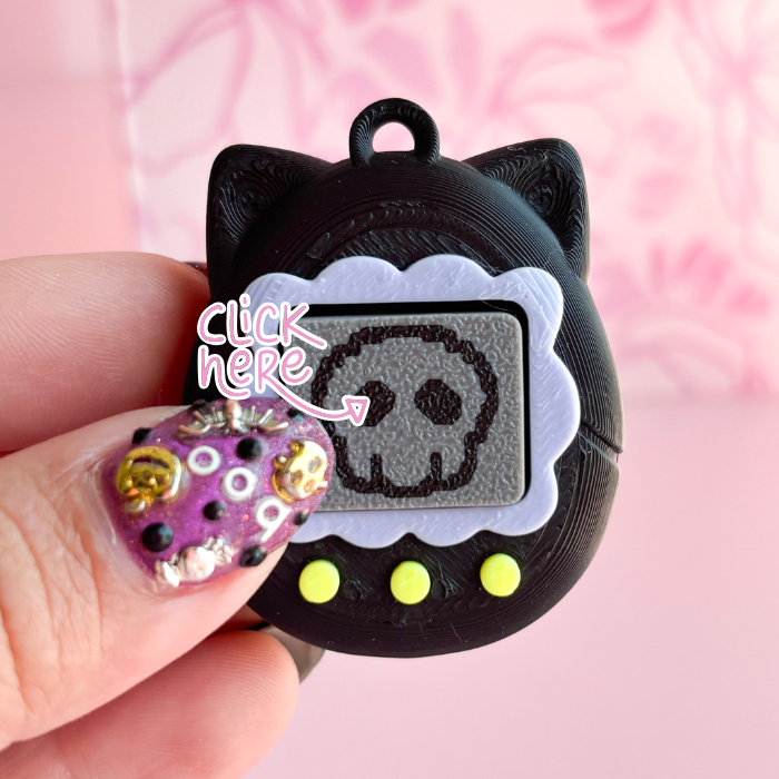 Black cat-shaped phone charm with a skull design on a pink background