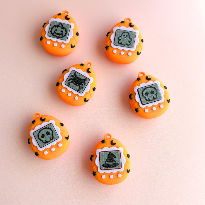 Set of orange toy devices with digital screens on a beige background