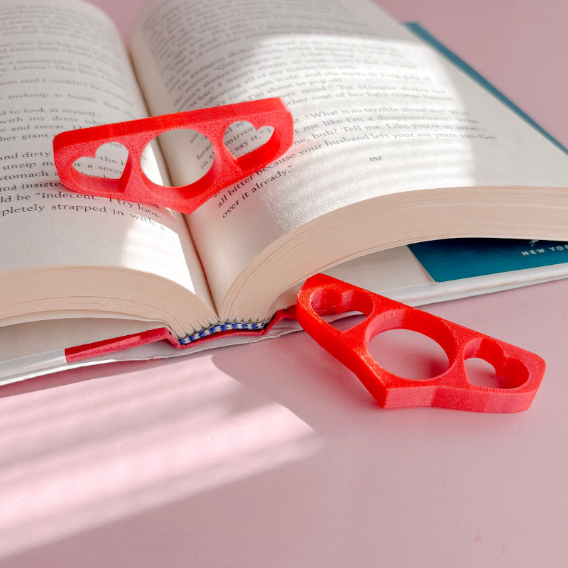 Book holder with hearts on an open book with a pink background