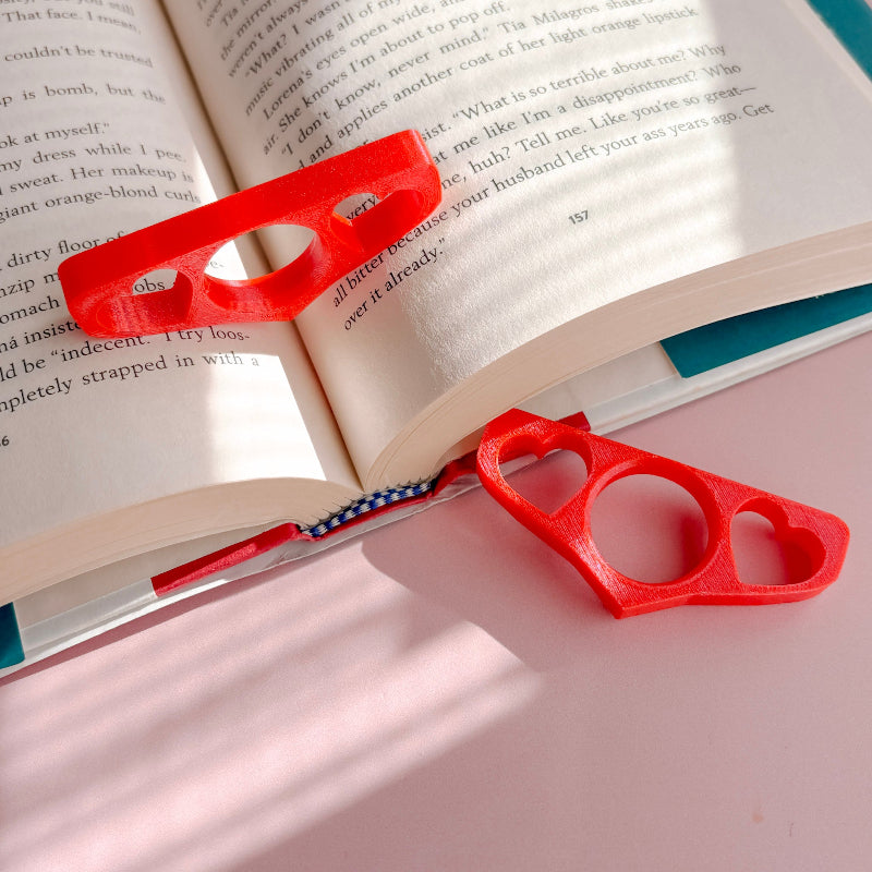 Book holder with hearts on an open book with a pink background