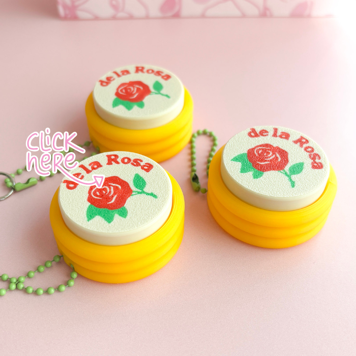 Yellow containers with 'de la Rosa' branding and a rose design on a pink background.