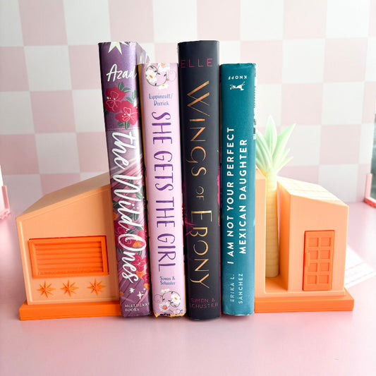 Four books on a pink checkered background with decorative bookends.