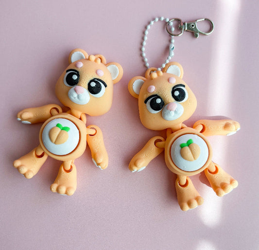 Two cartoonish animal keychains on a pink background