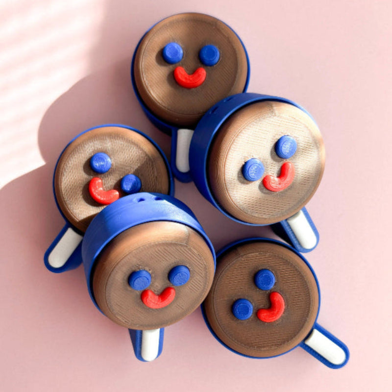 Five ice cream cone-shaped cookies with face designs on a pink background