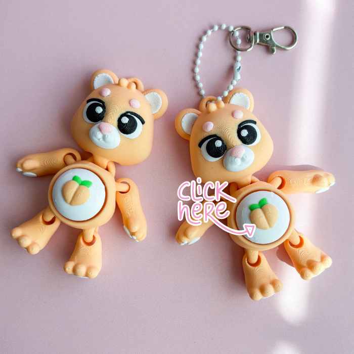 Two cartoon-like animal keychains on a pink background with text 'click here'.