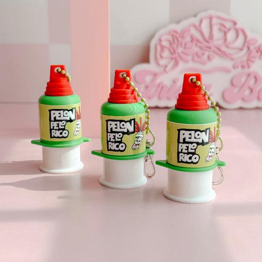 Three colorful plastic containers clickers with red lids and 'Pelon Peló Rico' branding on a pink background.