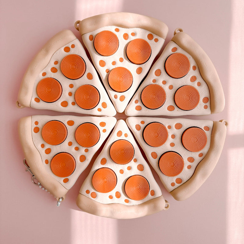 Fidget Clicker designed like a pizza with slices on a pink background