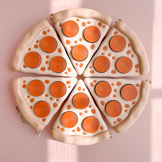 Fidget Clicker designed like a pizza with slices on a pink background