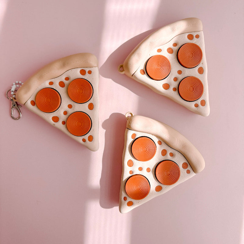 Fidget Clicker designed like a pizza with slices on a pink background