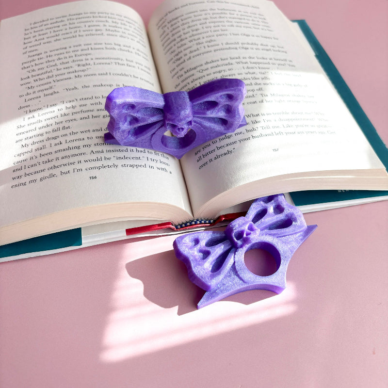 Purple butterfly-shaped bookmarks on an open book with a pink background
