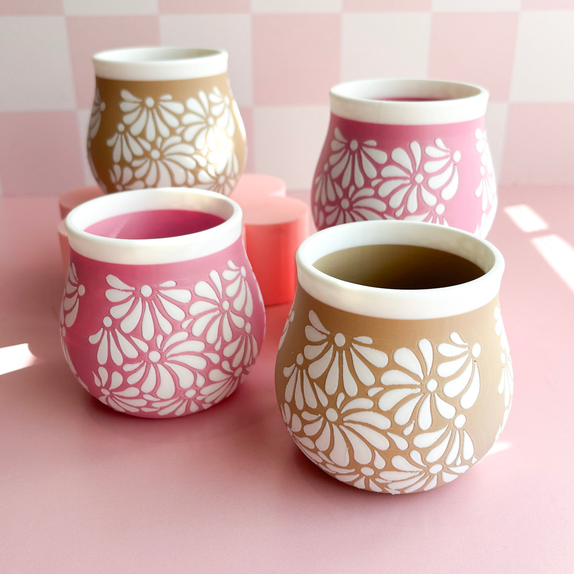 Two 3D printed pen holders with floral patterns on a pink background