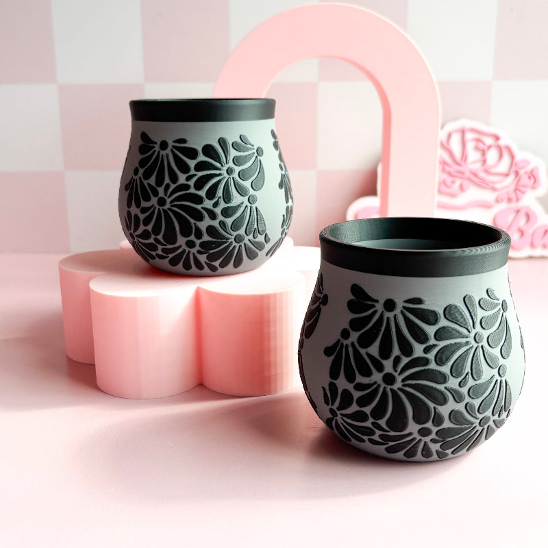 Two 3D Printed cups with floral patterns on a pink geometric background