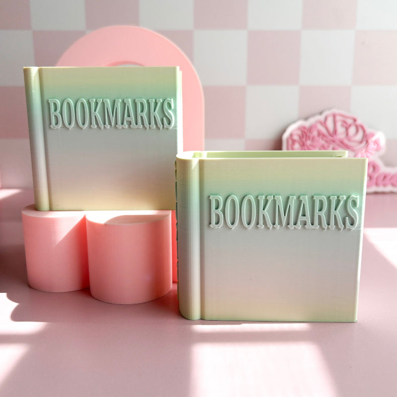 Two pastel-colored containers labeled 'BOOKMARKS' on a pink and white checkered background.