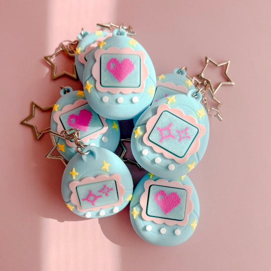 Set of blue VPet fidget clickers with heart designs on a pink background