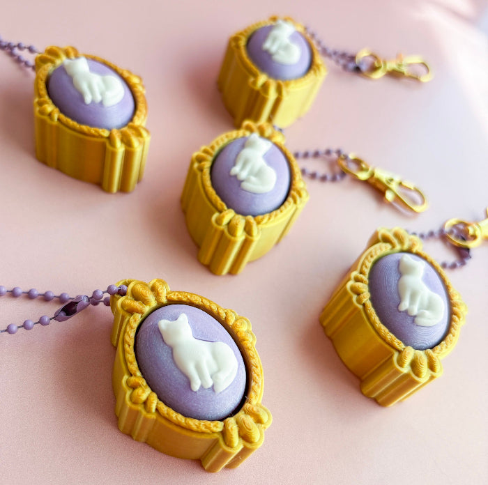 Four similar necklaces with purple stones and gold frames on a pink background