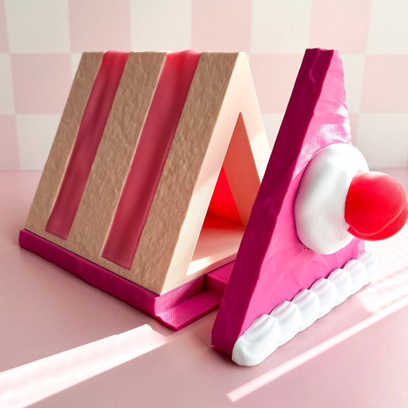 Book-shaped cake with a cherry on a pink surface