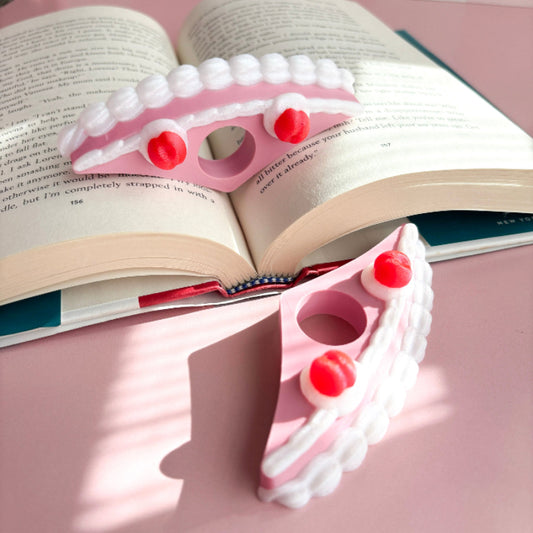 Pink book holder with red buttons on an open book