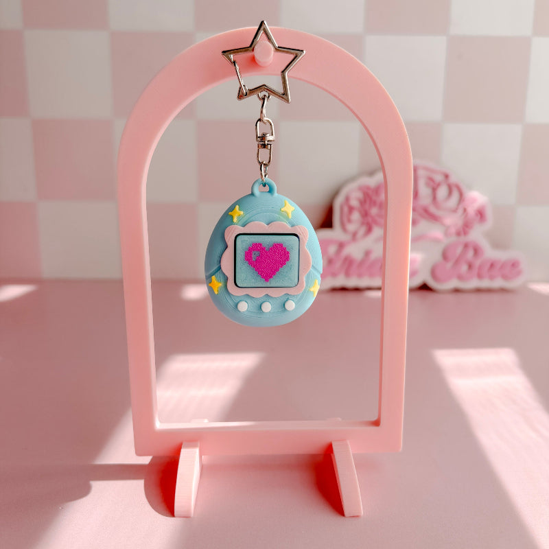 Set of blue VPet fidget clickers with heart designs on a pink background