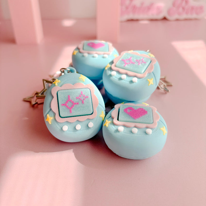 Set of blue VPet fidget clickers with heart designs on a pink background