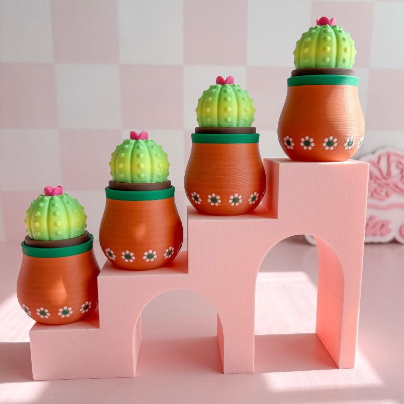 Set of cactus-shaped pots on a pink geometric shelf against a checkered background