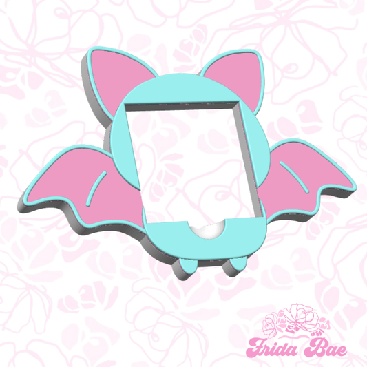 Teal and pink phone case with bat wings on a pink floral background