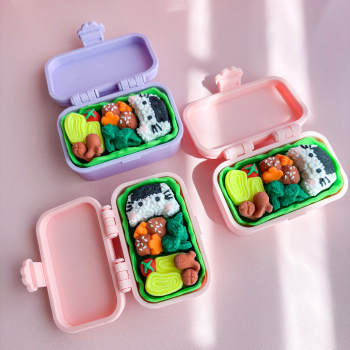Pink and purple bento box fidgets with food on a pink surface