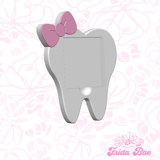 Tooth-shaped night light with a pink bow on a pink floral patterned background