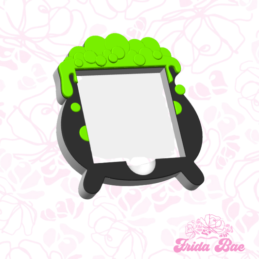 Green and black frame with a white center on a pink floral patterned background, featuring the brand 'Frida Bae'.