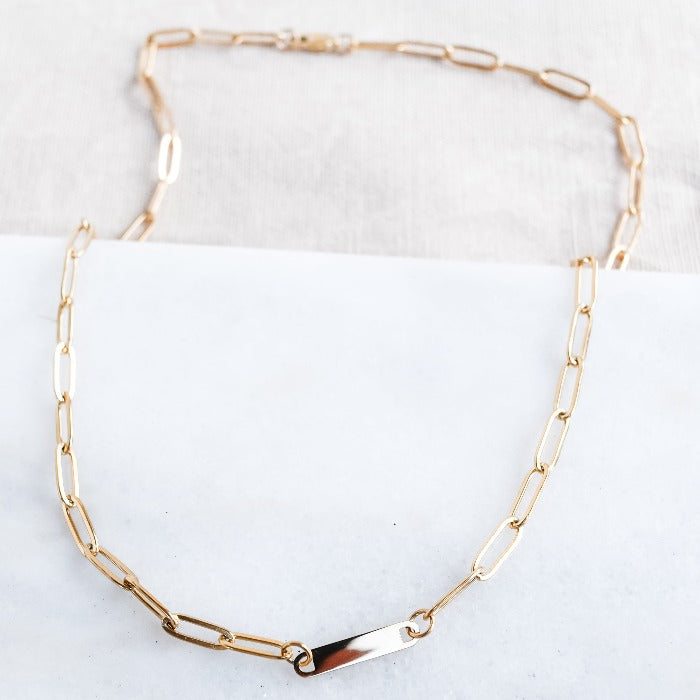 Elevate your style with our 1-Bar Paperclip Chain Necklace in gold. This fully customizable necklace features a sleek design and can be laser engraved in your choice of font. Make a statement and stand out from the crowd with this unique and personalized piece.