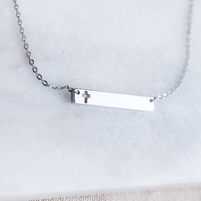 This polished gold necklace is the perfect accessory for any occasion! Featuring a beautifully engraved cross bar, it adds a touch of elegance and meaning to any outfit. Simple yet stunning, this necklace is a must-have in any jewelry collection