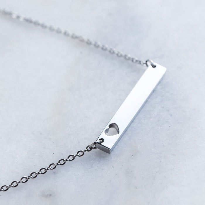 Show your love and dedication with our handcrafted heart bar necklace. The polished finish and 18" loop chain add a touch of elegance. Personalize with custom engraving for a heartfelt gift that will be treasured for years to come.