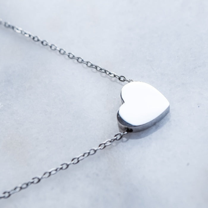 The River Heart Necklace is the perfect accessory to show your love and devotion. With a smooth, polished finish and a charming heart-shaped design, this necklace is custom engraved to make it uniquely yours. Elevate any outfit and add a touch of romance to your look with this beautiful and heartfelt piece.