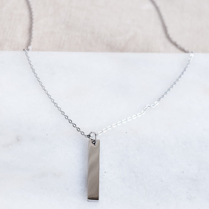 Add a touch of elegance to your everyday look with our Vertical Bar Pendant Necklace in Stainless Steel. Crafted from polished stainless steel, this lightweight necklace is perfect for daily wear and can be layered with other pieces. Its minimalistic design can also be engraved for a unique and personalized touch.