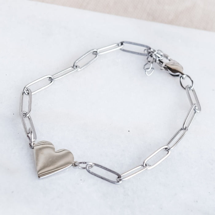 Add a touch of love to any outfit with our Nana paperclip heart bracelet. Featuring a chic paper clip design and adjustable chain, it pairs perfectly with our Riri paperclip heart necklace for a complete look. Perfect for a subtle yet stylish statement!