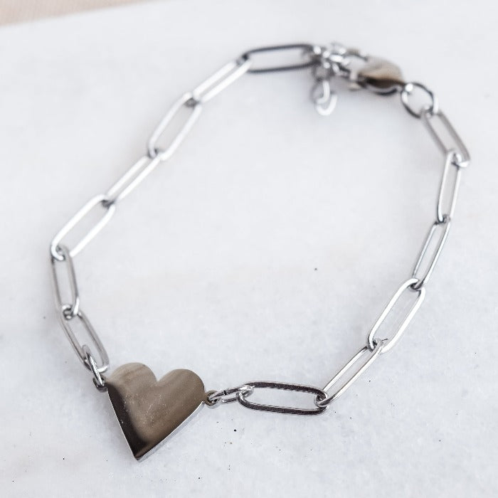 Add a touch of love to any outfit with our Nana paperclip heart bracelet. Featuring a chic paper clip design and adjustable chain, it pairs perfectly with our Riri paperclip heart necklace for a complete look. Perfect for a subtle yet stylish statement!