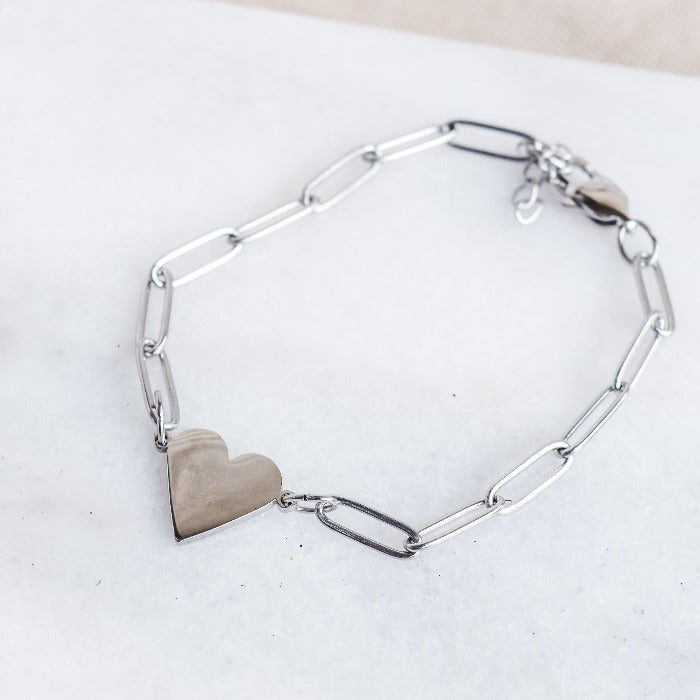 Add a touch of love to any outfit with our Nana paperclip heart bracelet. Featuring a chic paper clip design and adjustable chain, it pairs perfectly with our Riri paperclip heart necklace for a complete look. Perfect for a subtle yet stylish statement!