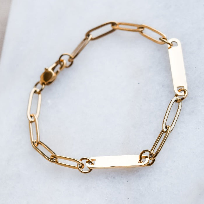 Elevate your style with our 2-Bar Paperclip Chain Bracelet in gold. This fully customizable necklace features a sleek design and can be laser engraved in your choice of font. Make a statement and stand out from the crowd with this unique and personalized piece.