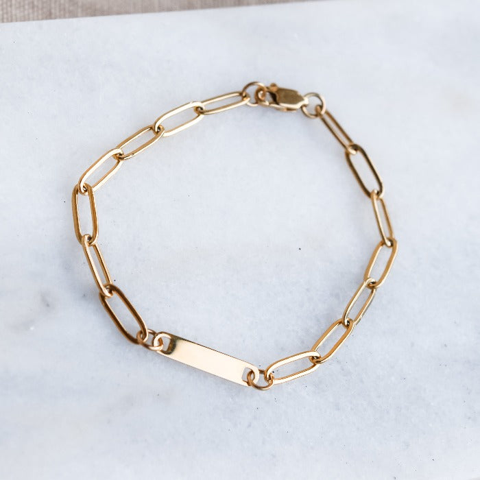 Elevate your style with our 1-Bar Paperclip Chain Bracelet in gold. This fully customizable necklace features a sleek design and can be laser engraved in your choice of font. Make a statement and stand out from the crowd with this unique and personalized piece.