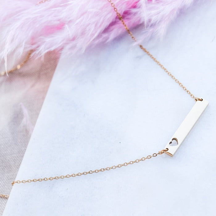 Show your love and dedication with our handcrafted gold heart bar necklace. The polished finish and 18" loop chain add a touch of elegance. Personalize with custom engraving for a heartfelt gift that will be treasured for years to come.