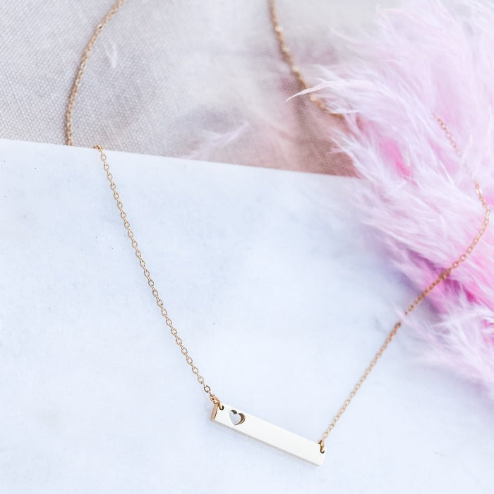 Show your love and dedication with our handcrafted gold heart bar necklace. The polished finish and 18" loop chain add a touch of elegance. Personalize with custom engraving for a heartfelt gift that will be treasured for years to come.
