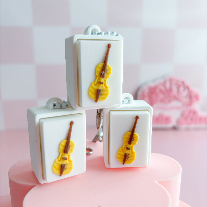 Mexican loteria fidget clicker with cello designs on a pink surface and light pink background