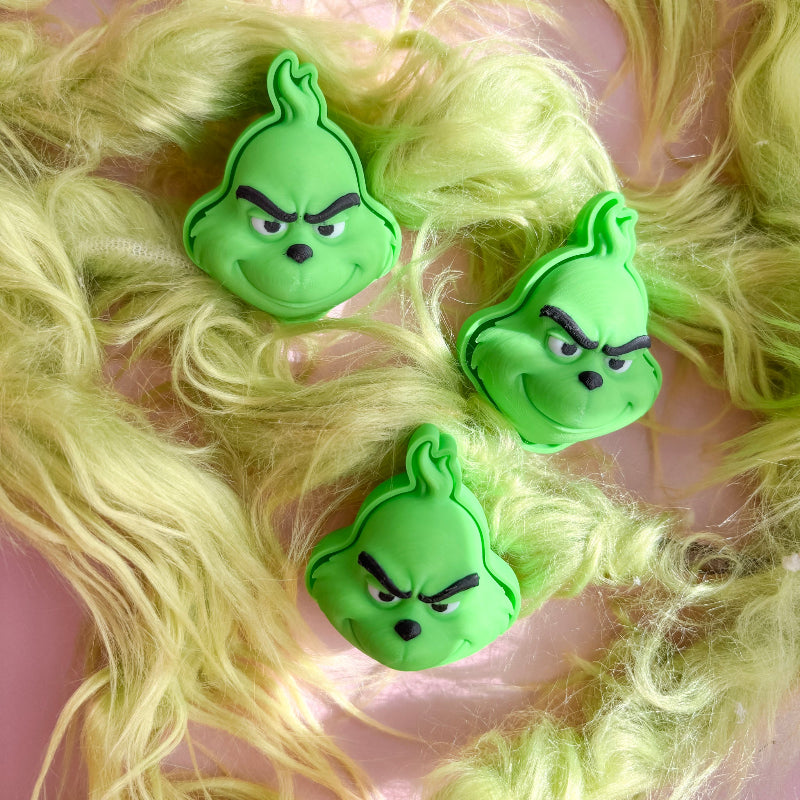 Green character hair clips on a person with blonde hair
