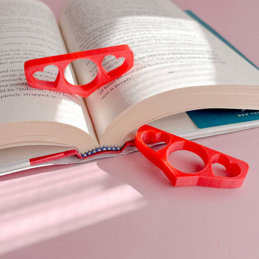 Book holder with hearts on an open book with a pink background