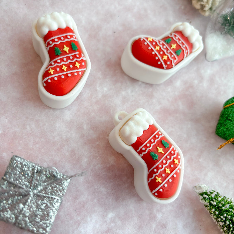Decorative Christmas fidget clicker items on a textured surface with a snowy background.